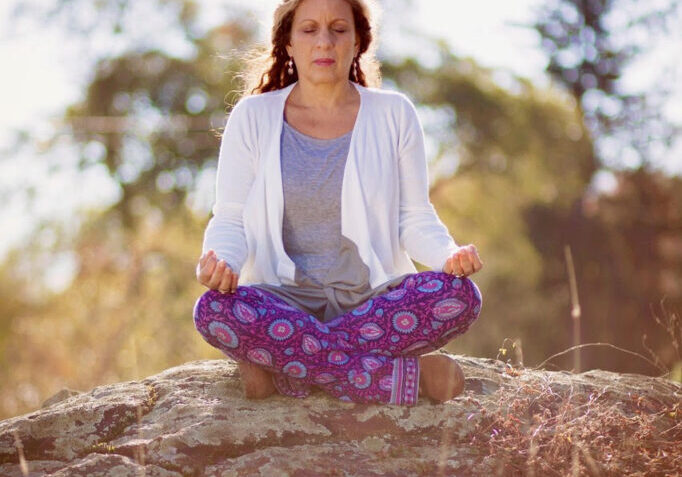 Cynthia meditating on rock